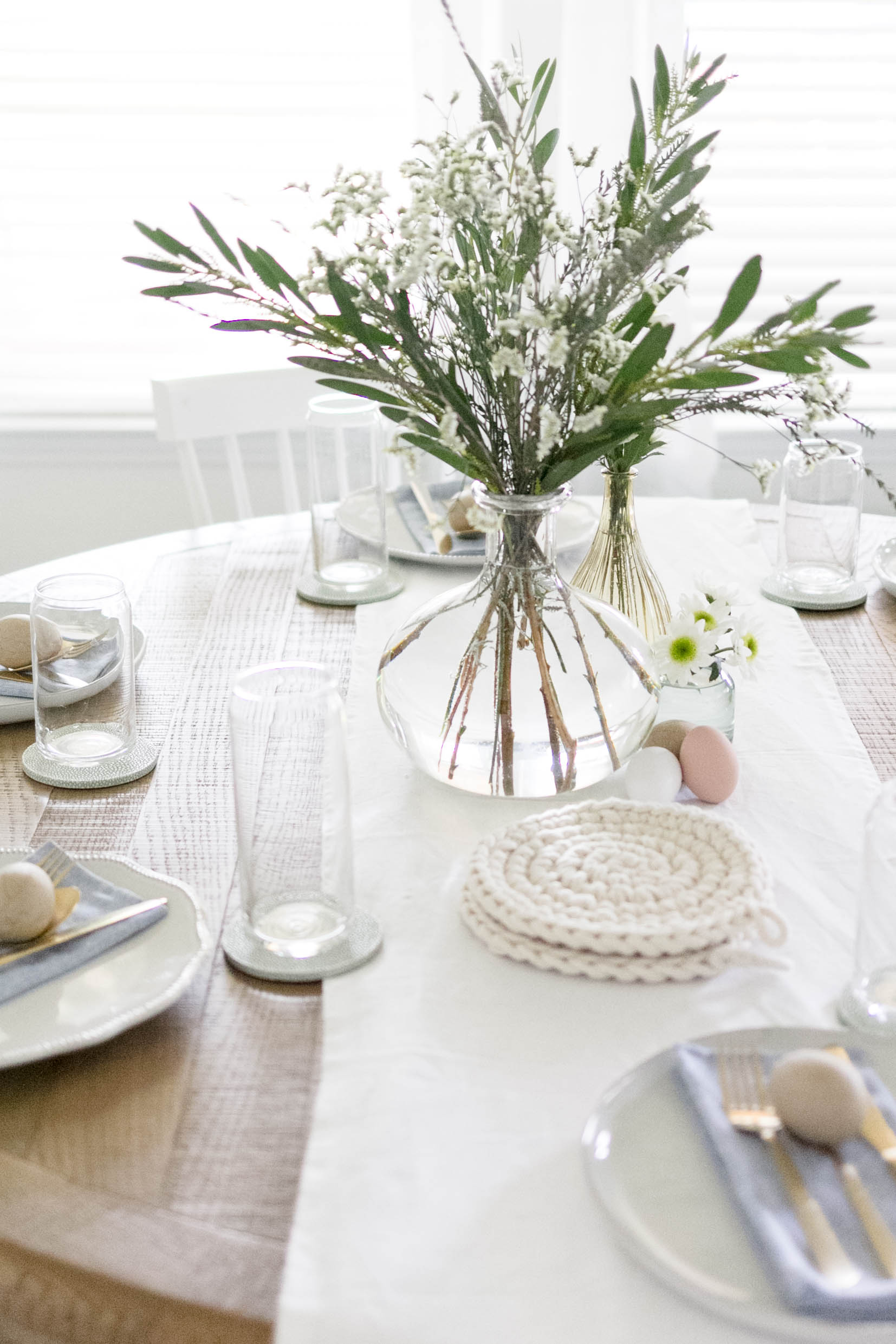 Double table Easter tablescape, with floral centerpieces, and simple tableware.