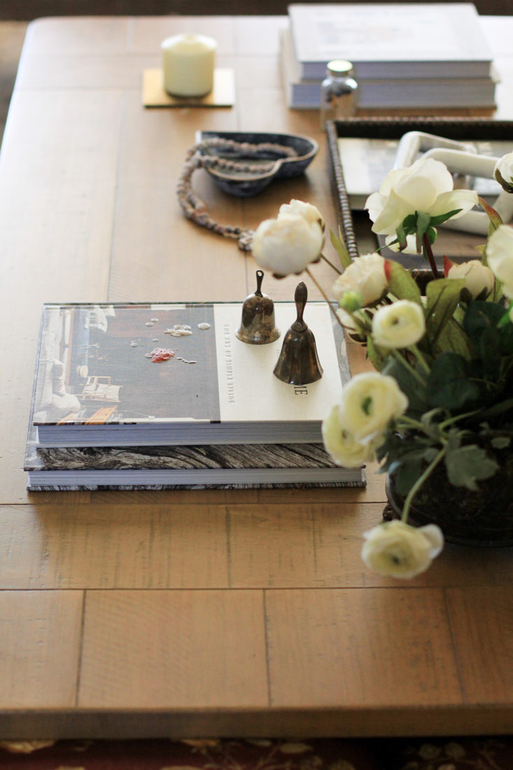 Romantic Coffee Table Styled with a White Floral Arrangement, Coffee Table Books, and Candles